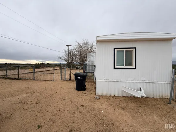 a white house that has a tree in front of it