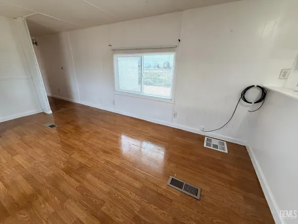 a view of a room with wooden floor and fan