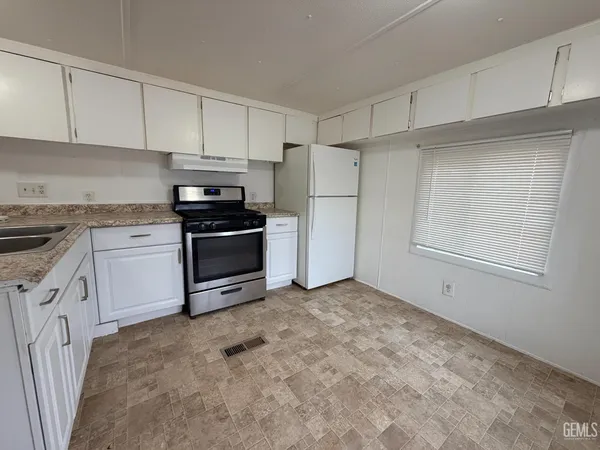 a kitchen with white cabinets and white appliances