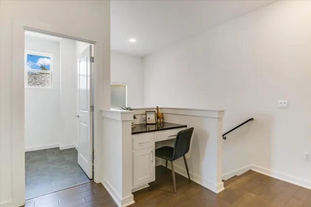 a view of a hallway with workspace and wooden floor
