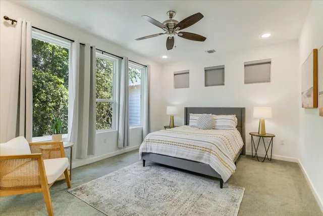 a spacious bedroom with a bed and glass window