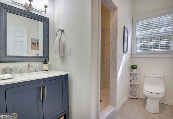 a bathroom with a toilet a sink and a mirror