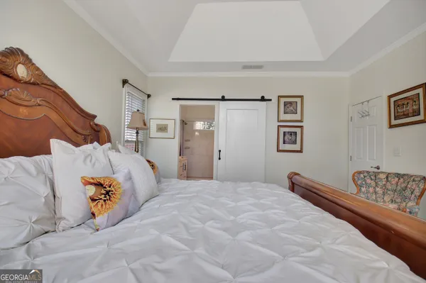 a bedroom with a bed and a painting on the wall