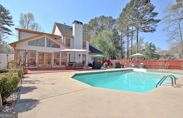 a view of a house with swimming pool and sitting area