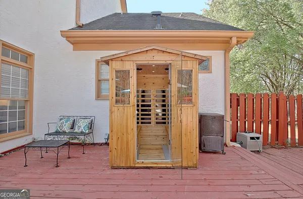 a view of front door of house and wooden deck