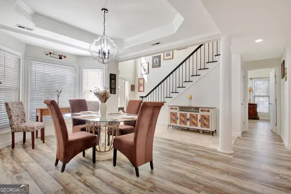 a view of a dining room with furniture wooden floor and chandelier