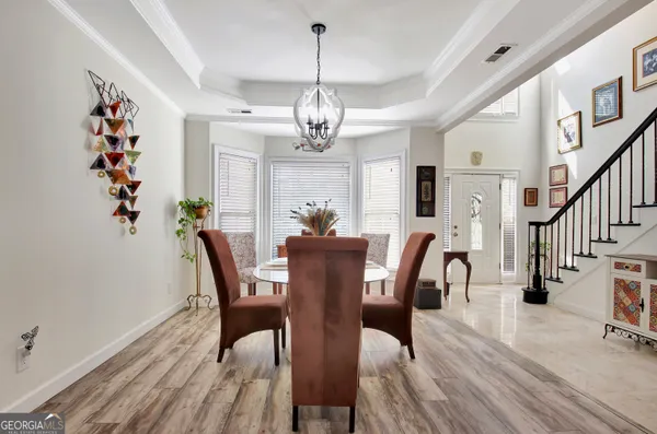 a view of a dining room with furniture wooden floor and chandelier