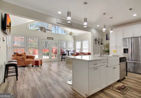 a large white kitchen with lots of counter space and chandelier