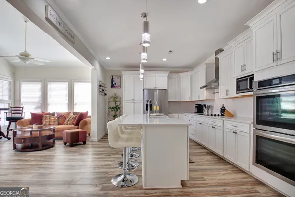 a kitchen with kitchen island granite countertop a sink cabinets and stainless steel appliances