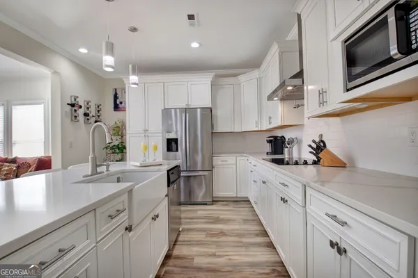 a kitchen with white cabinets and stainless steel appliances