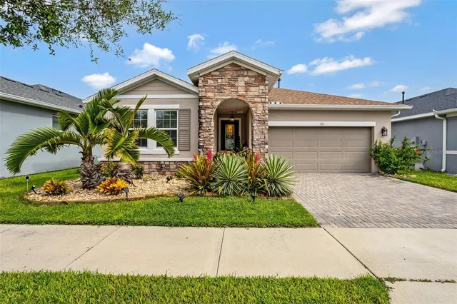 a front view of a house with a garden and plants
