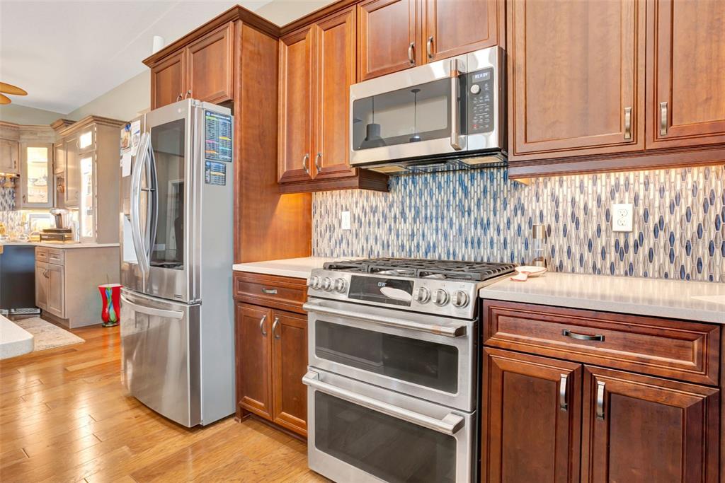 176 Silver Maple Road Groveland, FL 34736 - Photo 12 of 45 a kitchen with stainless steel appliances granite countertop a stove a refrigerator and a microwave