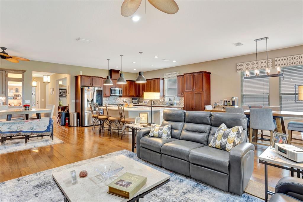 176 Silver Maple Road Groveland, FL 34736 - Photo 19 of 45 a living room with furniture kitchen view and a chandelier