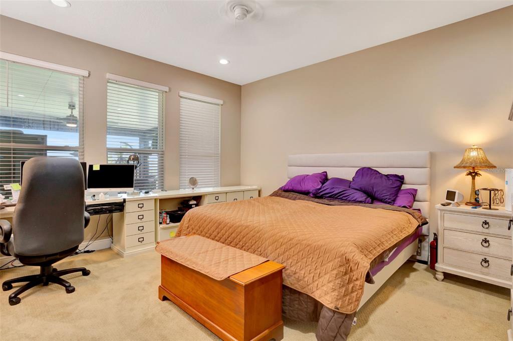 176 Silver Maple Road Groveland, FL 34736 - Photo 21 of 45 a bedroom with a bed a desk and chair with window