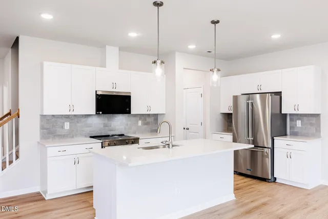 a kitchen with stainless steel appliances a refrigerator sink and microwave