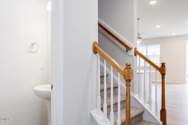 a view of staircase with railing and white walls