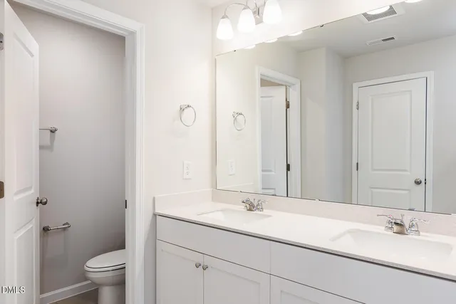 a bathroom with a sink a toilet and a mirror