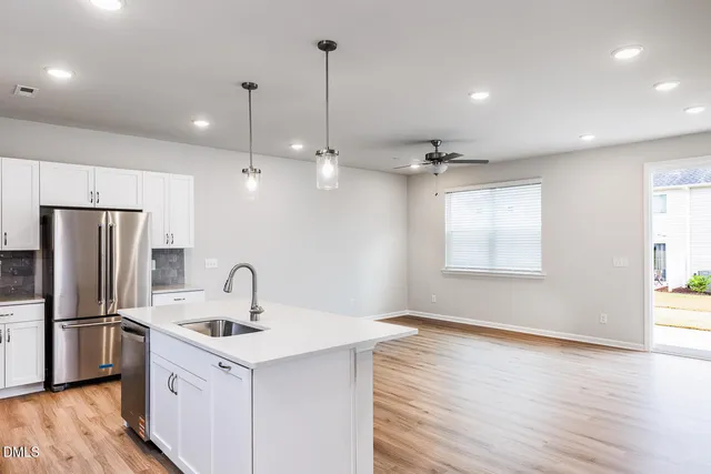 a kitchen with a refrigerator sink and cabinets