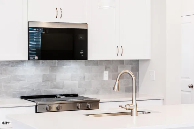 a close view of a stove a microwave and cabinets