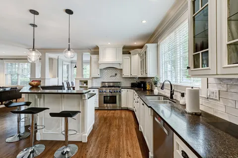 a kitchen with stainless steel appliances granite countertop a sink a stove top oven a counter space and cabinets