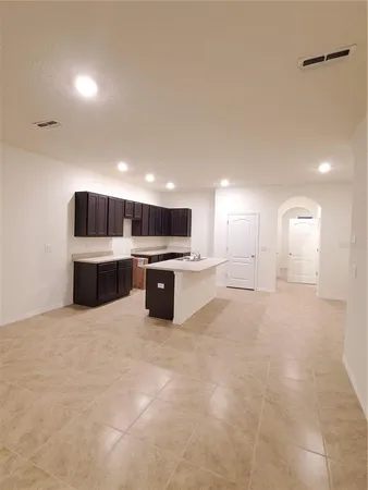 a large white kitchen with stainless steel appliances cabinets a sink and a stove