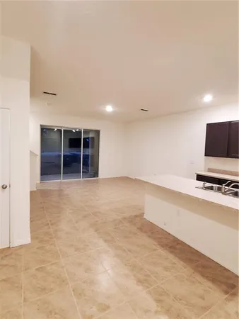 a view of a room with cabinet a flat screen tv and kitchen view