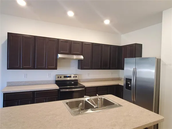 a kitchen with wooden cabinets and stainless steel appliances