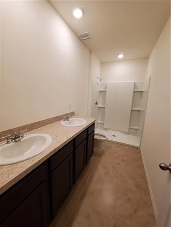 a spacious bathroom with a granite countertop sink a mirror and a bathtub