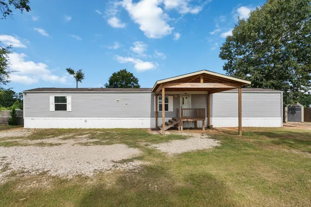 a view of a house with backyard and sitting area