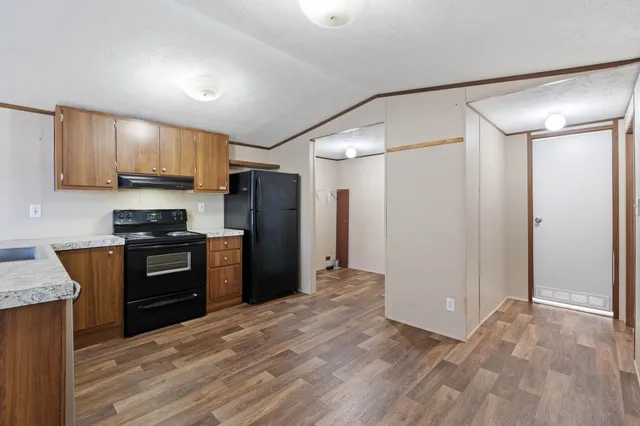 a kitchen with granite countertop a refrigerator stove and sink