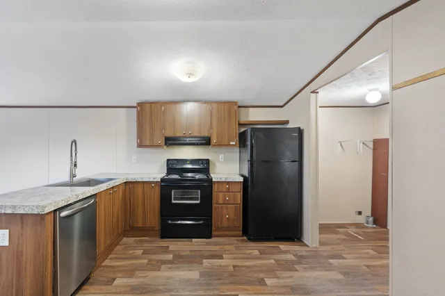 a kitchen with stainless steel appliances granite countertop a refrigerator stove and sink