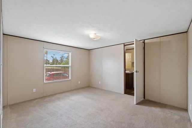 an empty room with windows and closet
