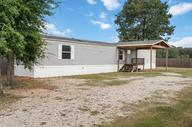 a view of a house with backyard and trees