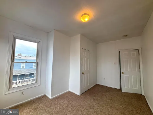 an empty room with windows and closet