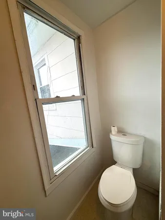 a white toilet sitting next to a window