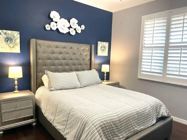 a bedroom with a bed mirror and window