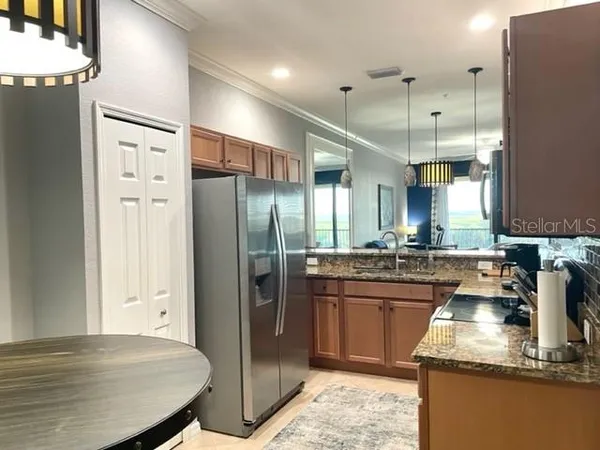 a kitchen with stainless steel appliances granite countertop refrigerator sink and stove