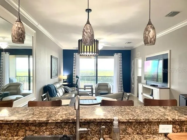 a living room with large window chandelier and couch
