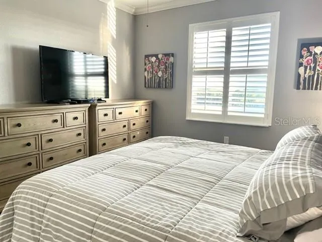 a bedroom with a bed and a flat screen tv
