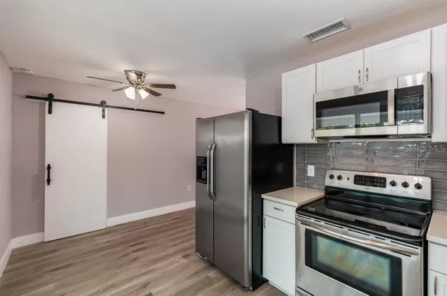 a kitchen with stainless steel appliances a refrigerator a stove and cabinets