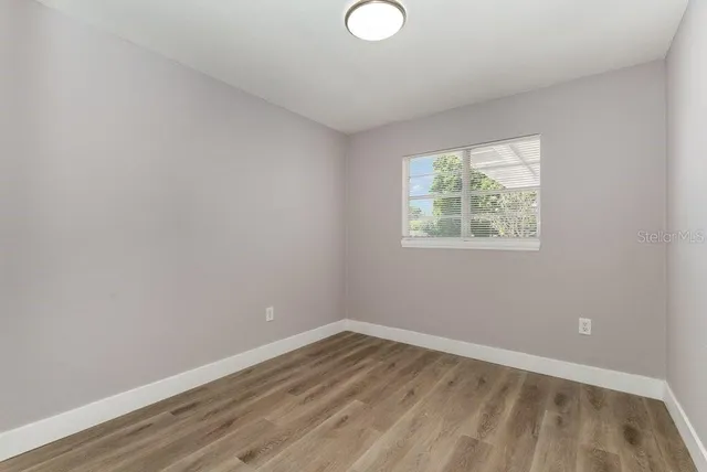 a view of a room with wooden floor and windows