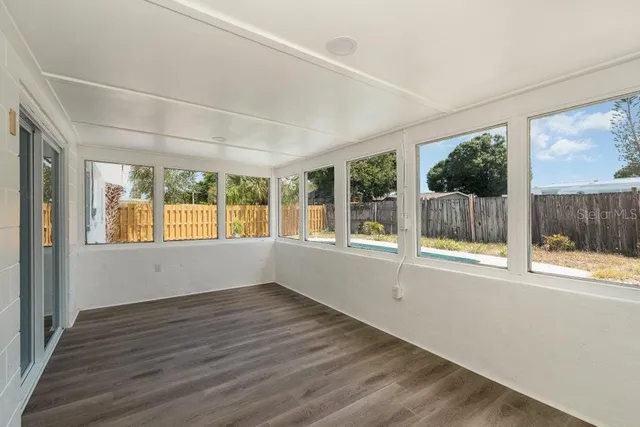 an empty room with wooden floor and a window