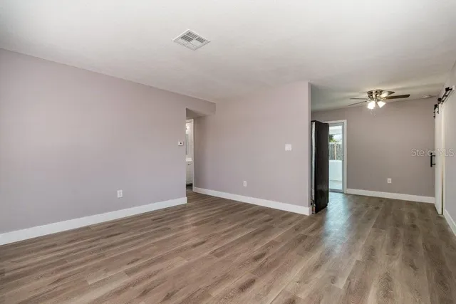 a view of an empty room with wooden floor