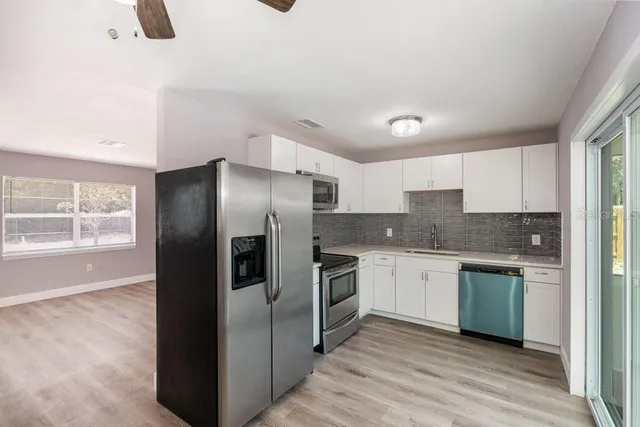 a kitchen with stainless steel appliances granite countertop a refrigerator and a stove top oven