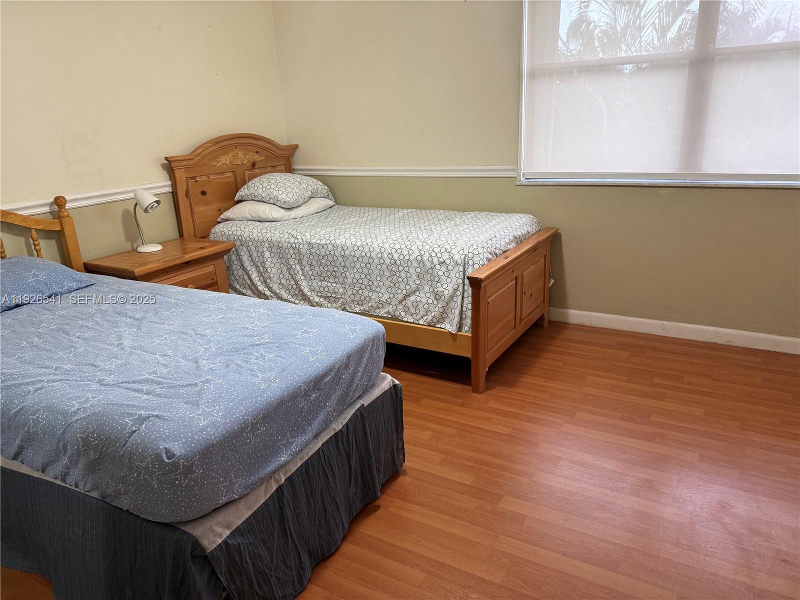 9901 Northwest 9th St Circle, Unit 32 Miami, FL 33172 - Photo 11 of 14 a bedroom with two beds and wooden floor