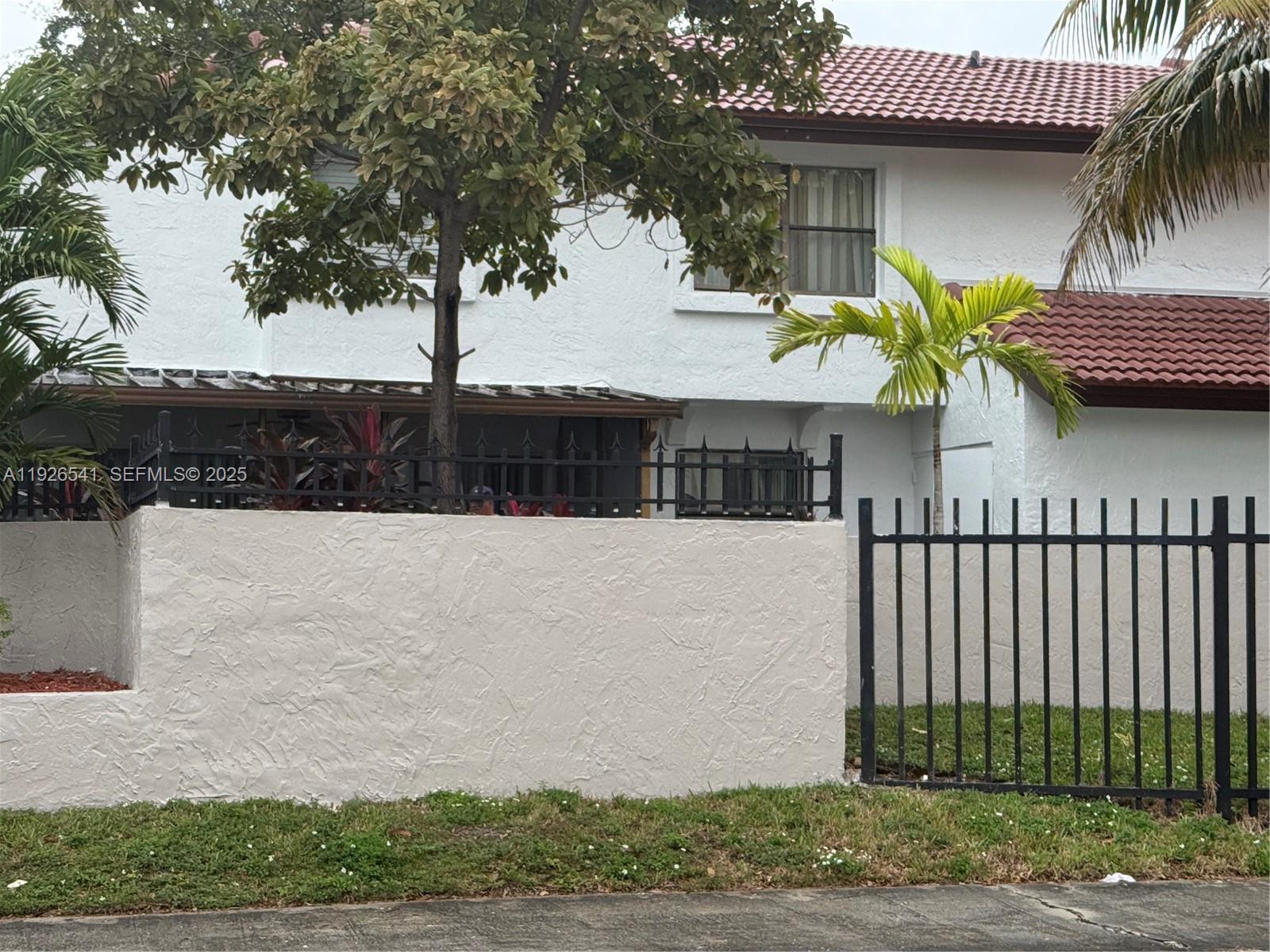 9901 Northwest 9th St Circle, Unit 32 Miami, FL 33172 - Photo 2 of 14 a view of a house with a iron fence