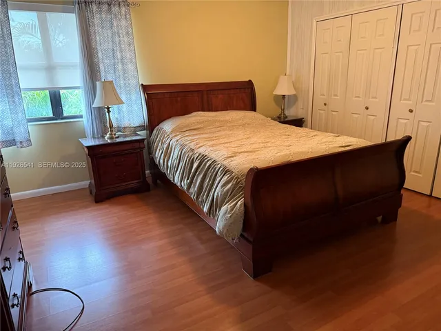 a bed sitting in a spacious bedroom next to a window