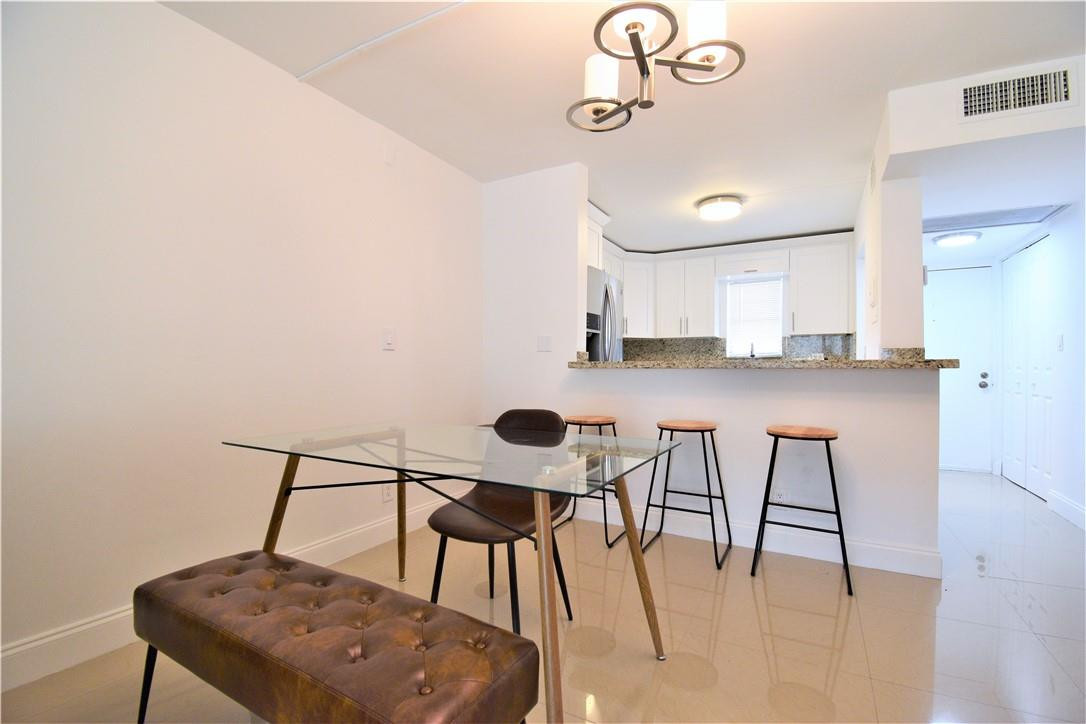 9273 Southwest 8th Street, Unit 407 Boca Raton, FL 33428 - Photo 2 of 19 a view of a workspace with furniture and a table