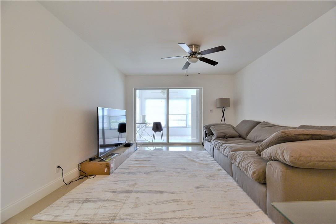 9273 Southwest 8th Street, Unit 407 Boca Raton, FL 33428 - Photo 3 of 19 a living room with furniture and a window