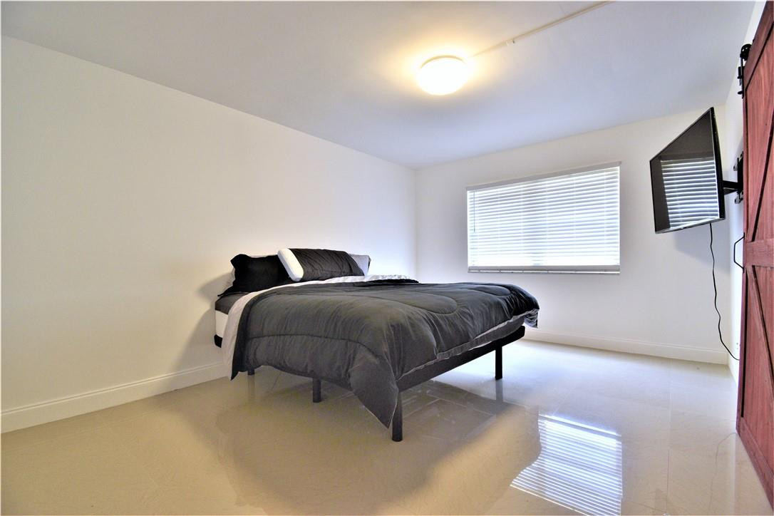 9273 Southwest 8th Street, Unit 407 Boca Raton, FL 33428 - Photo 7 of 19 a bedroom with a bed and window